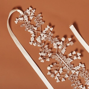 Detailed close-up of handmade bridal headband with white pearls and faceted crystals