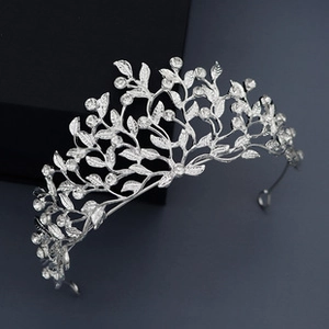 Macro detail of silver bridal tiara featuring rhinestone leaves and vine patterns