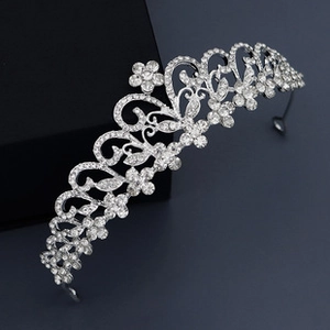 Close-up of silver baroque crown with crystal floral patterns and pink diamonds