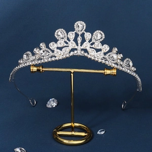 Detail shot of silver princess crown with clear rhinestones on a metal display stand