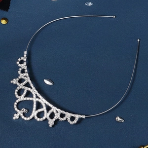 Close-up of silver tiara hair comb with sparkling rhinestones and heart scroll pattern