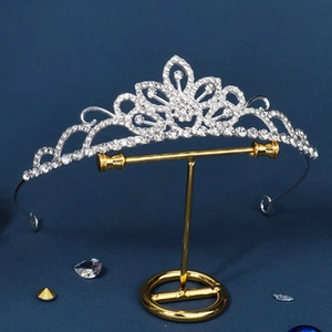Detail of silver rhinestone princess tiara crown with floral patterns on display stand