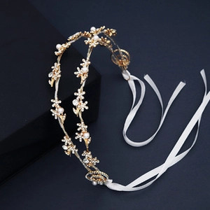 Détail d'un serre-tête floral doré avec perles et rubans blancs pour filles