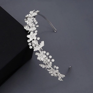 Détail des fleurs en acrylique et des perles sur ce bandeau de mariée argenté élégant