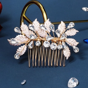 Detailed view of bridal hair comb with gold leaves and sparkling rhinestones