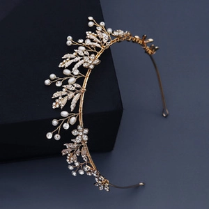 Détail d'un diadème doré floral avec des perles blanches élégantes et cristaux clairs