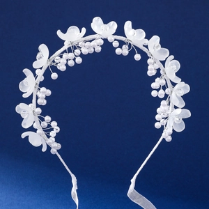 Détails des pétales givrés blancs et des perles sur ce serre-tête élégant de cérémonie