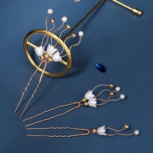 Detailaufnahme von Maiglöckchen-Haarnadeln mit Goldfinish und weißen Perlenbesatz