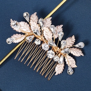Exquisite gold bridal hair comb with crystal leaves and rhinestones on blue fabric