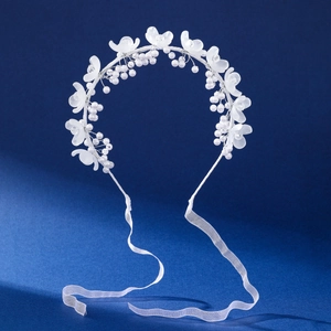 Détail d'un serre-tête floral fait main avec pétales blancs, perles et rubans de soie