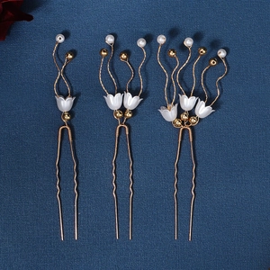 Detail von drei handgefertigten Blumen-Haarnadeln mit Goldplattierung und Perlen