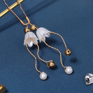 Detaillierte Makroansicht goldener Maiglöckchen-Haarnadeln mit Perlen und Quasten