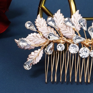 Macro view of gold bridal hair comb with rhinestone leaves and sparkling crystals