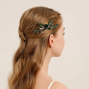 Détail d'un peigne à cheveux artisanal en cristal vert porté par un modèle