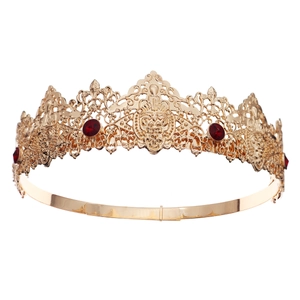 Detailed view of baroque vintage gold crown with intricate carving and deep red gems
