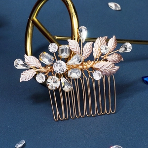 Macro detail of handmade bridal hair comb with gold leaves and sparkling crystals