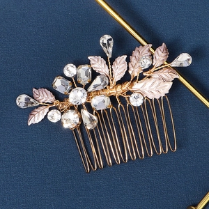 Macro detail of bridal hair comb with gold wire leaves and sparkling rhinestones