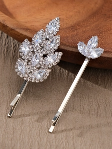 Vue détaillée de barrettes feuilles argentées avec strass marquise sur tissu texturé