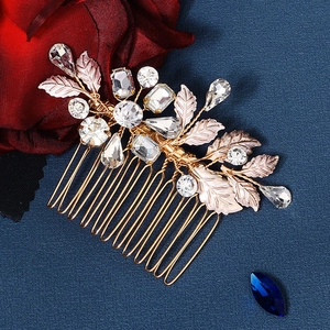 Detailed close-up of bridal hair comb featuring pink metal leaves and sparkling rhinestones