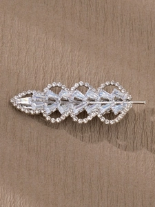 Vue détaillée d'une pince à cheveux feuille avec monture argentée et strass brillants