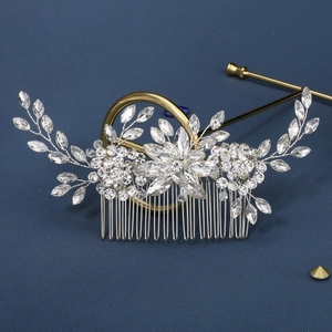Elegant silver bridal hair comb with marquise rhinestones on a textured blue surface