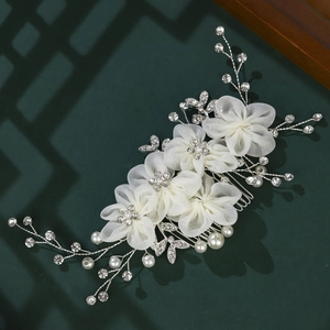Peigne à cheveux de mariée élégant avec fleurs en tissu, perles et strass sur fond vert