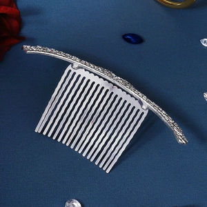 Elegant silver alloy bridal hair comb with sparkling crystals on dark blue background