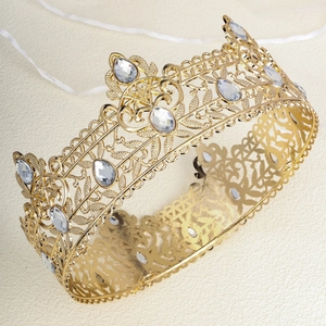 Detailed macro view of vintage gold crown with teardrop rhinestones and intricate cutouts