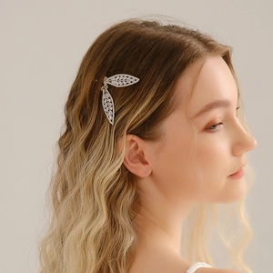 Pince à cheveux feuille en métal argenté avec strass portée par un mannequin sur fond clair