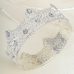 Detailed close-up of intricate baroque silver tiara with sparkling crystal teardrop rhinestones