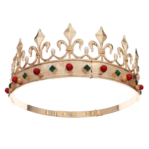 Close-up of golden baroque crown with iris patterns, red and green gems and white pearls