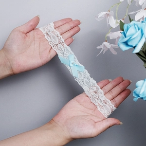 White floral lace bridal garter featuring a soft blue satin bow and central pearl bead