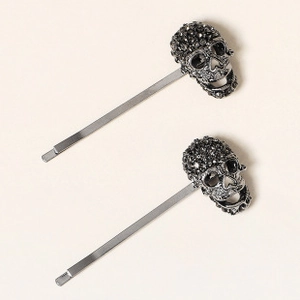 Detalle de dos pinzas para el pelo de araña gótica con diamantes negros en metal