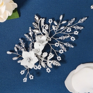 Close-up of handmade bridal hair comb with ceramic flowers, pearls and crystal branches