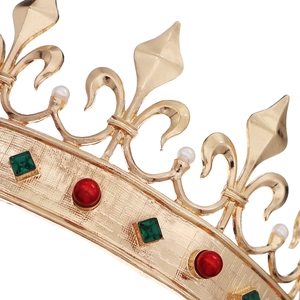 Macro view of vintage gold crown detailing green gemstones and lily flower engravings