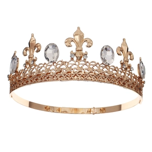 Close-up of golden crown featuring fleur-de-lis patterns and clear crystals