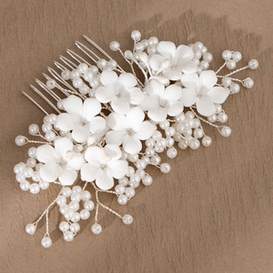 Detail of bridal hair comb with white resin flowers and silver wire faux pearls