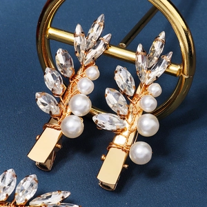 Barrettes à cheveux dorées en forme de feuille avec cristaux et perles sur fond bleu