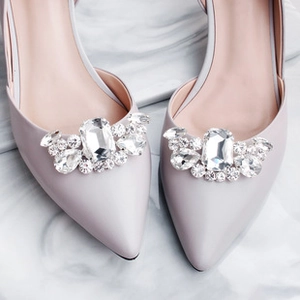 Close-up of elegant pointed toe shoe with sparkling rhinestone sunflower buckle decoration