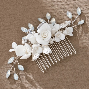 Detailed shot of handmade ceramic floral bridal hair comb with blue crystals and silver leaves
