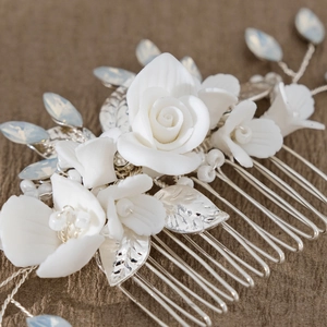 Macro detail of handmade bridal hair comb with white ceramic flowers and silver leaves