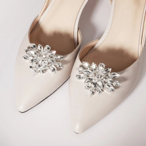 Detailed view of luxury rhinestone floral shoe clips on elegant cream pointed heels
