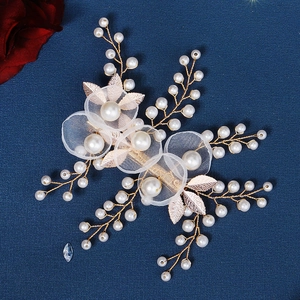 Detailaufnahme der handgefertigten Braut-Haarklammer mit Goldblättern und Perlenblumen