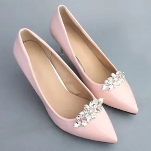 Detail of detachable rhinestone sunflower shoe clips on pink pointed stiletto heels