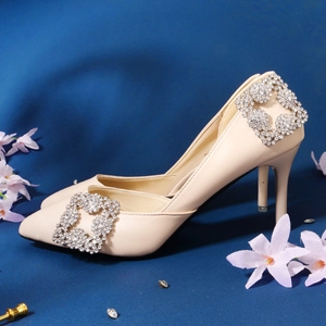 Close-up of sparkling square rhinestone shoe clip on elegant beige pointed high heel
