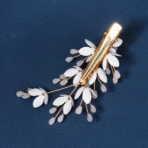 Exquisite handmade flower hair clip with white leaves and gold wire on blue background