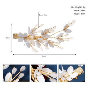 Detail showing white flower and gold leaves hair clip with 80mm measurement scale