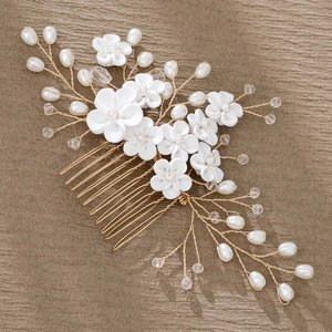 Detail of handmade bridal hair comb with ceramic flowers, pearls, and crystals on gold wire