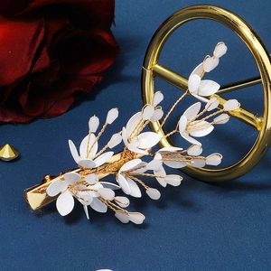 Elegant handmade crystal flower hair clip with gold metal base on blue background