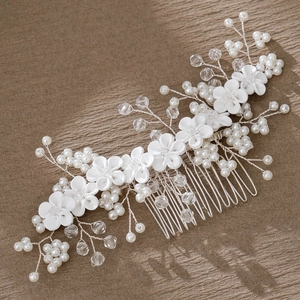 Close-up of bridal hair comb with handmade white fabric flowers, pearls and crystals